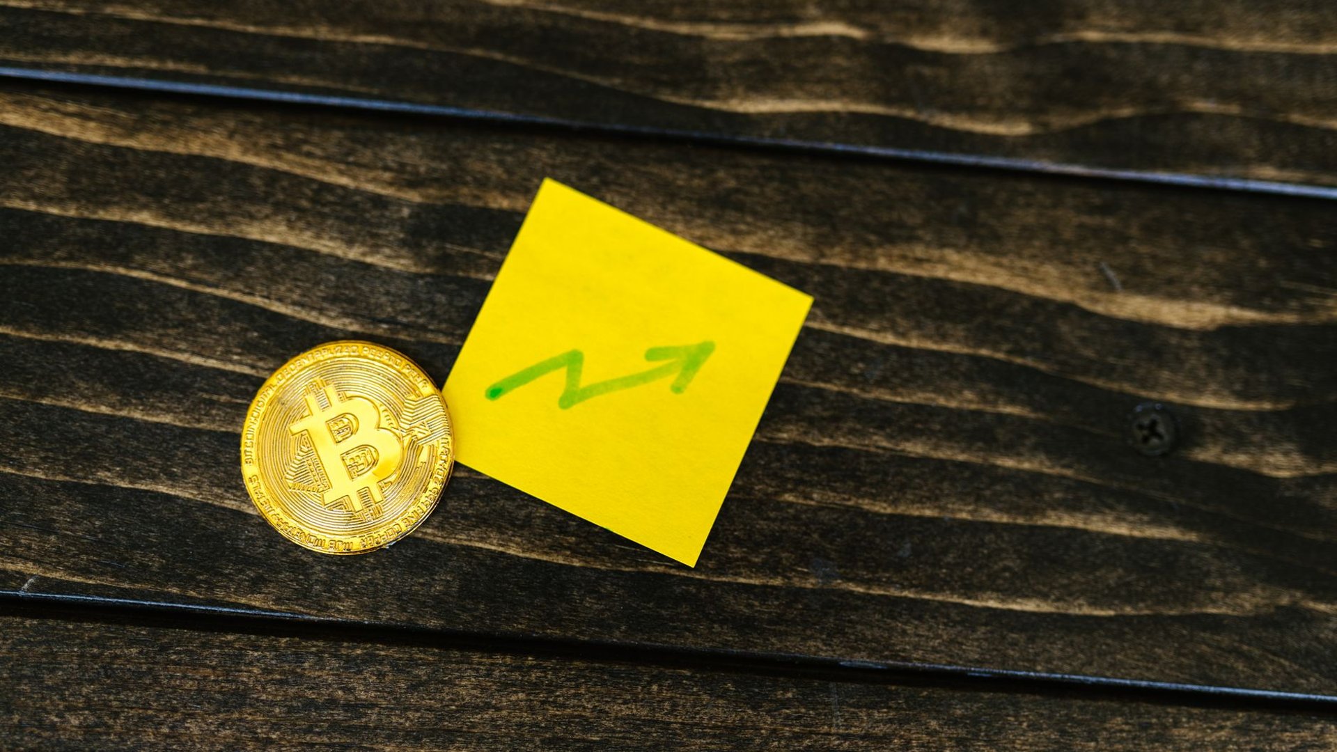 Bitcoin-Münze neben handgezeichnetem Aufwärtspfeil, Symbolbild Kursgewinn beim Verkauf