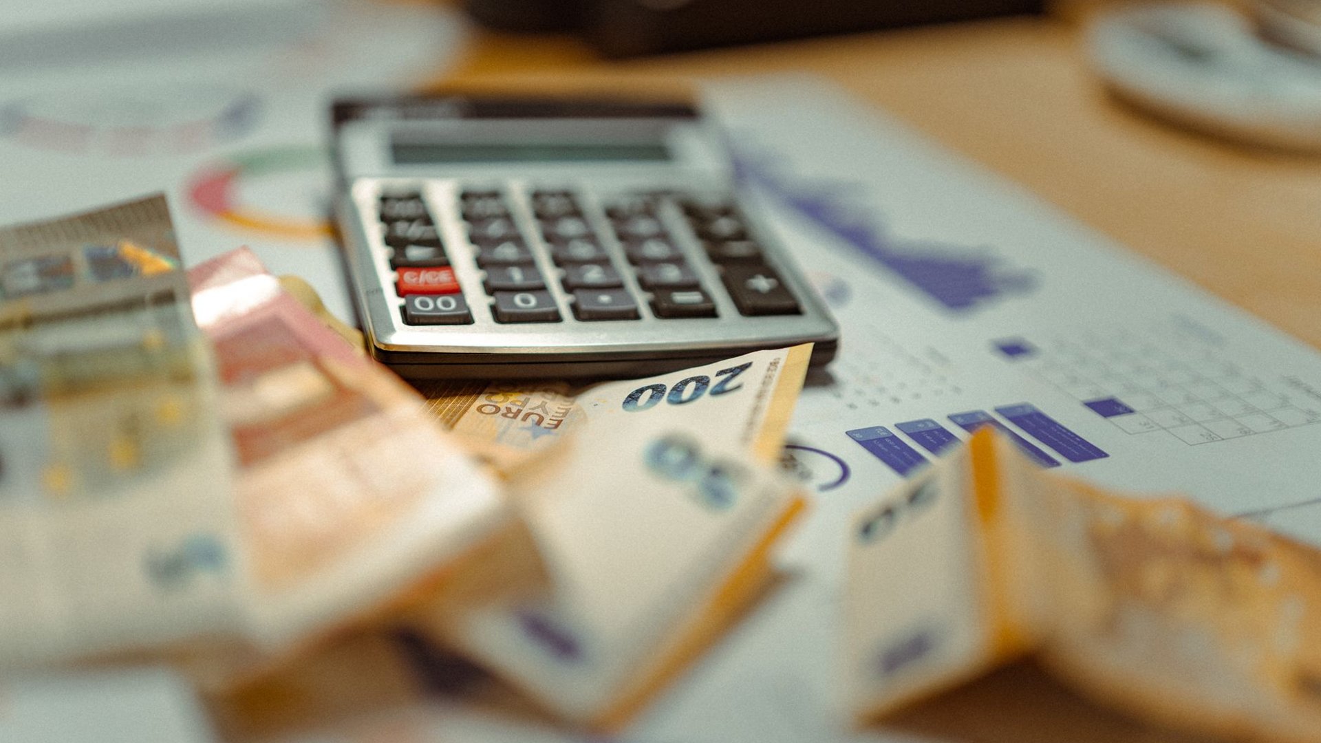 Taschenrechner und Euro-Banknoten auf Finanzdokument, Symbolbild Krypto-Casino-Steuer