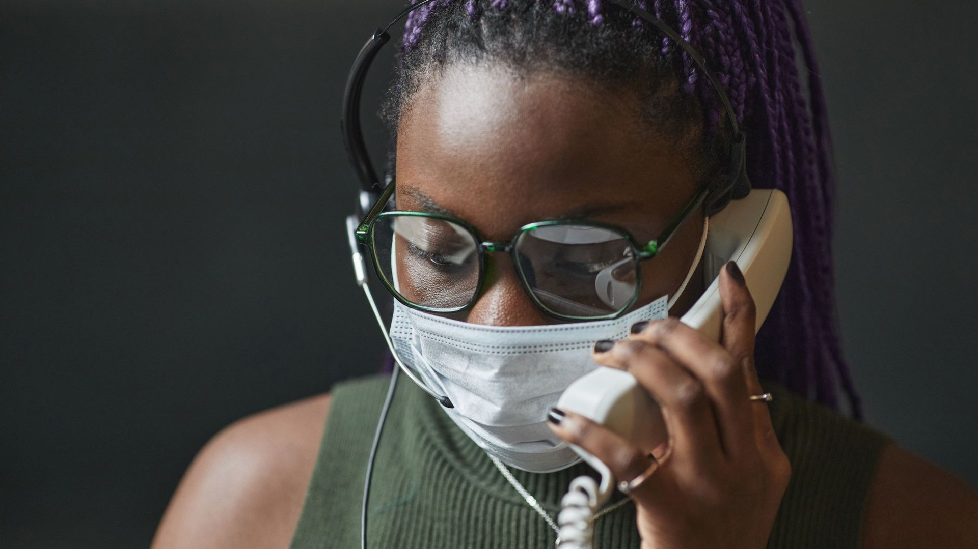Beraterin mit Headset nimmt am Telefon einen anonymen Hilfe-Anruf zur Glücksspielsucht entgegen